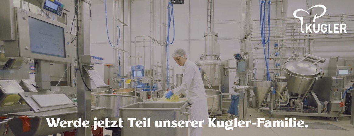 Mitarbeiter mit Weißkleidung in der Produktion, im Hintergrund Maschinen und Anlagen.